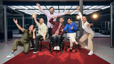 Two associates are playing on a football table with a Bosch Rexroth APAS assistance robot.